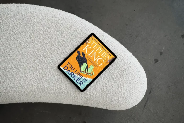 A tablet displaying the book cover of You Like It Darker by Stephen King resting on a textured white surface
